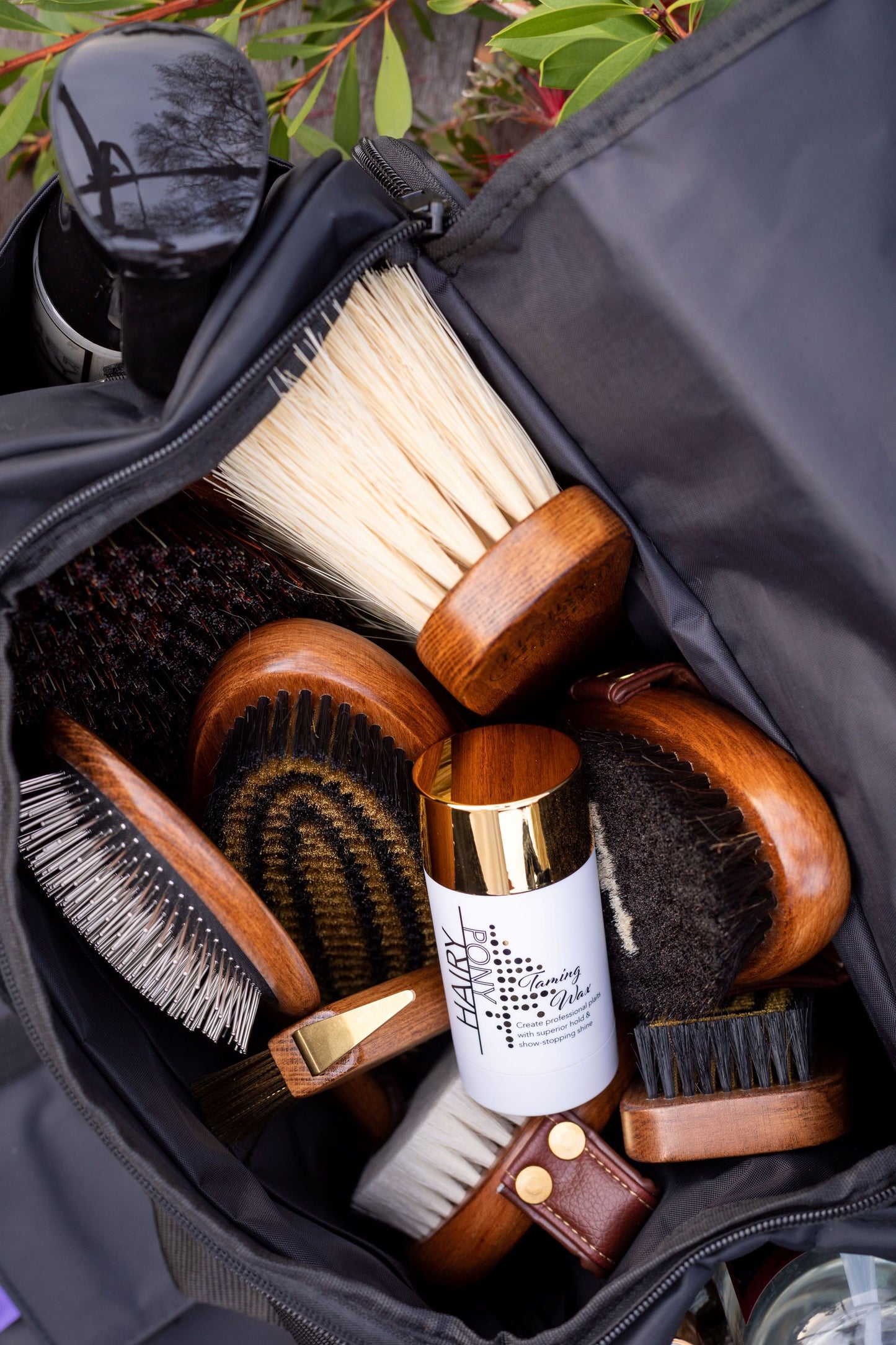 A view of various Hairy Pony grooming products in a Hairy Pony Grooming Bag, including the Hairy Pony Flick Brush.