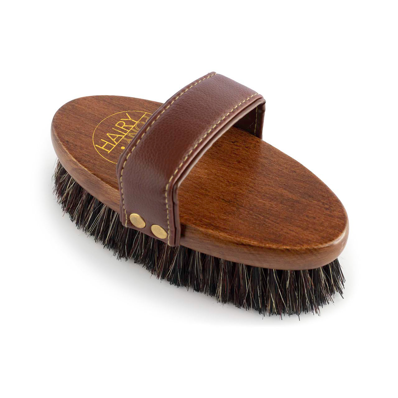 A view of the top of the Hairy Pony Dandy Brush, showing the soft, padded handle, gold detailing and synthetic bristles.