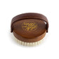 A view of the top side of the Hairy Pony Face Briush, showing the soft padded handle, gold logo detailing and beechwood material on the back of the brush.