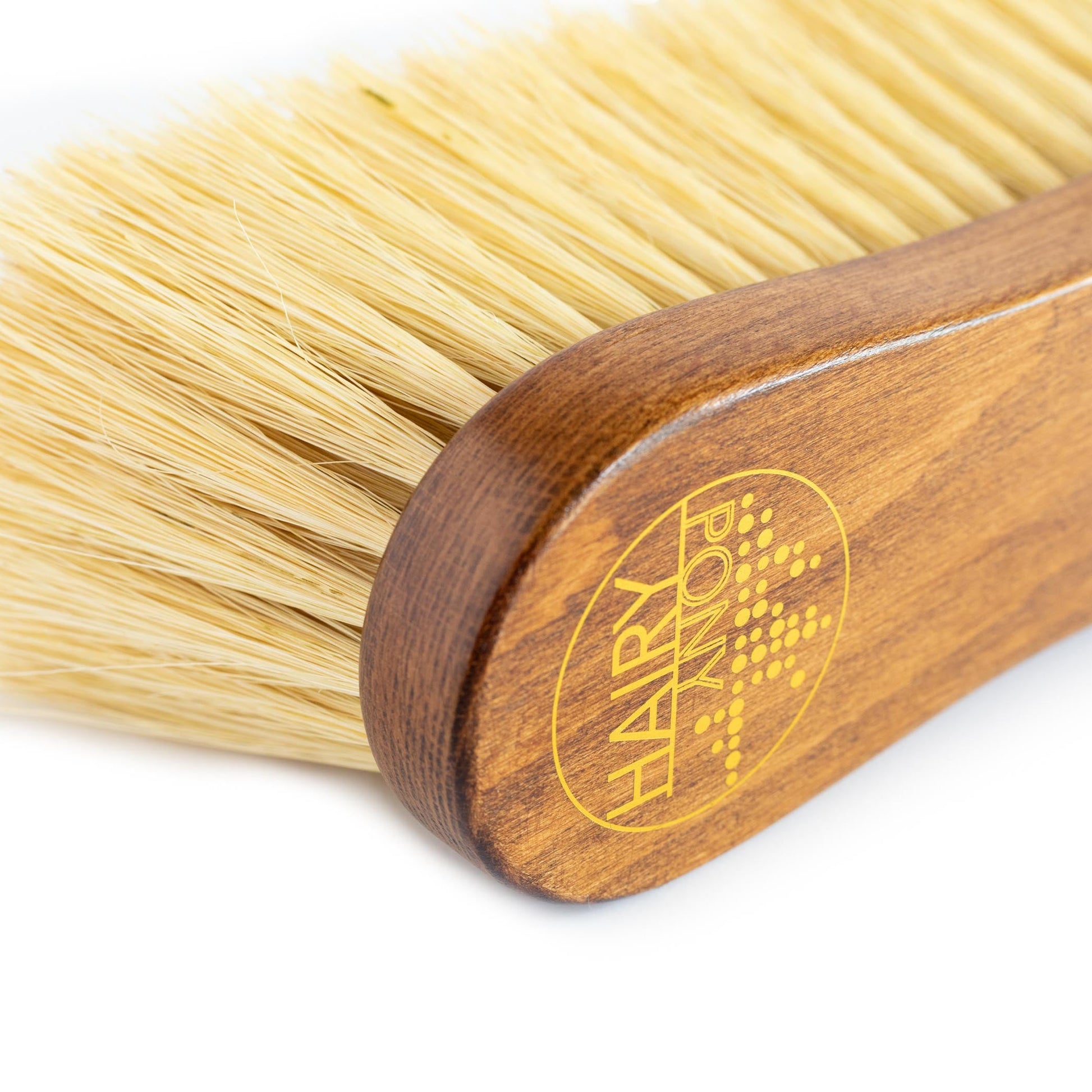 A close up view of the Hairy Pony Flick Brush, showing the long bristles and gold logo detailing.