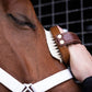 The Hairy Pony Face Brush being used on a horse's face.