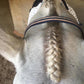 A forelock braided and finished with the fastening scissors